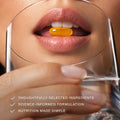 Close-up of a woman taking a supplement softgel with RevitaPlus Beauty Pack’s science-informed daily nutrition approach